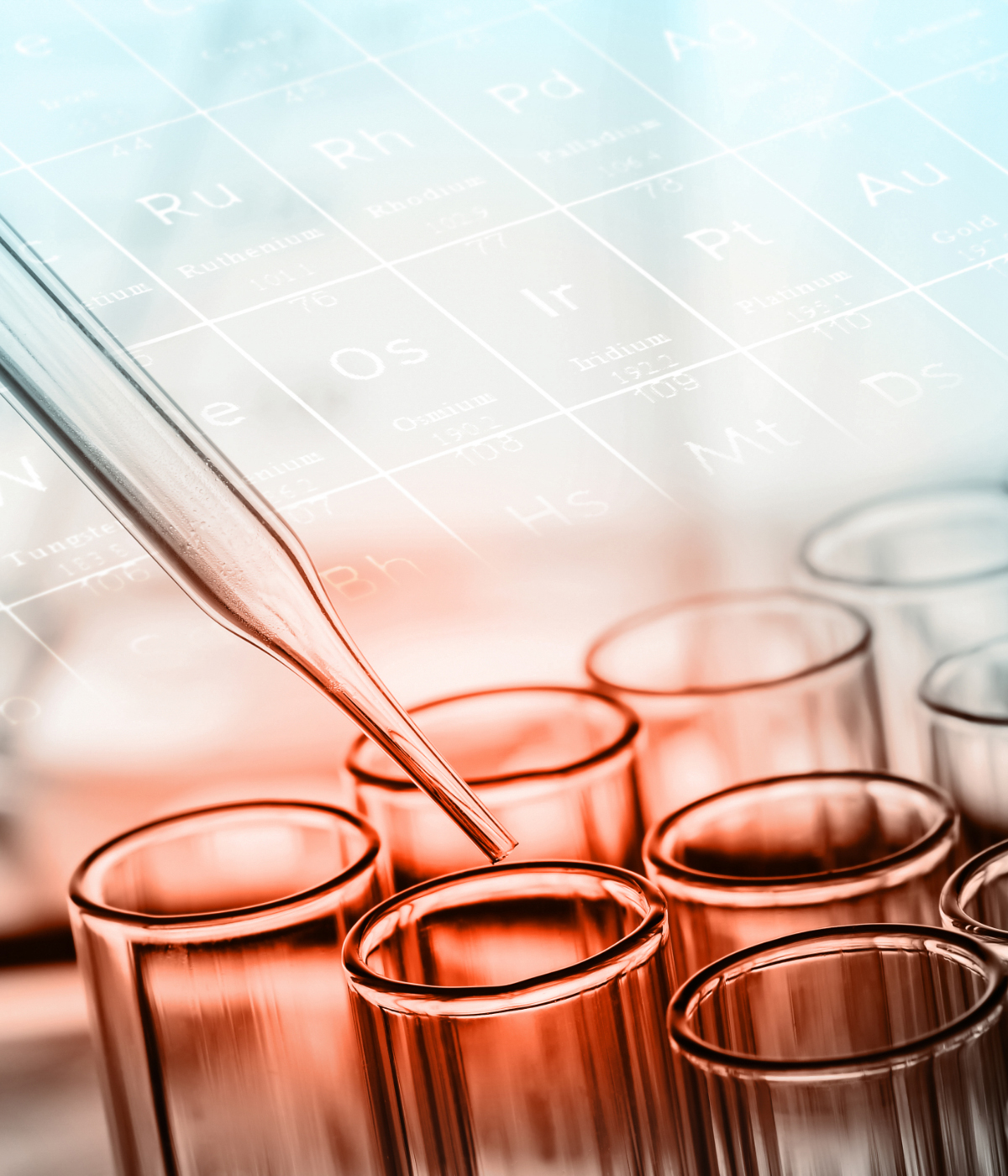 Dropper inserted into test tube with periodic table superimposed.